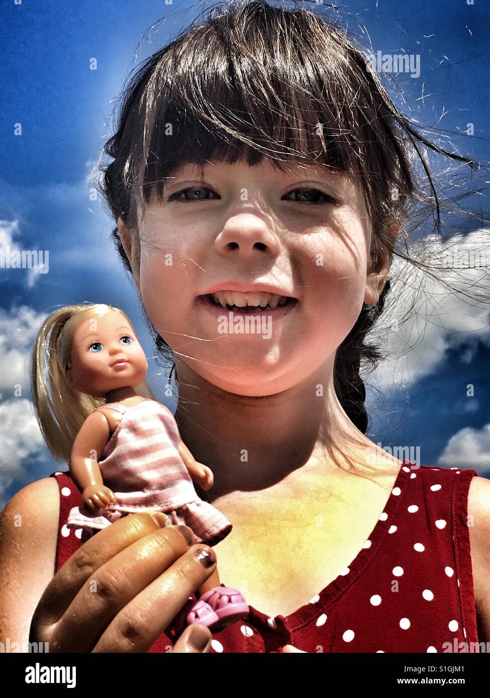 Mädchen hält eine Puppe - Smartphone-aufgenommenes Stockfoto Mädchen hält eine Puppe - Smartphone-aufgenommenes Stockfoto