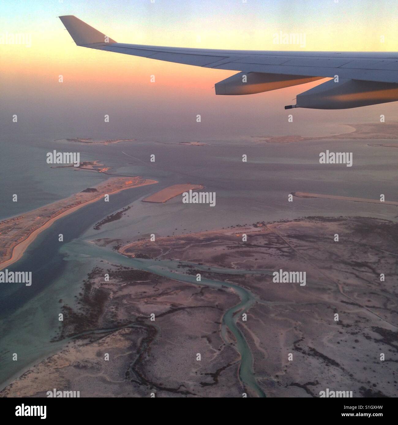 Ein Flugzeug über der Wüste von Dubai mit einem wunderbaren Sonnenaufgang Stockfoto