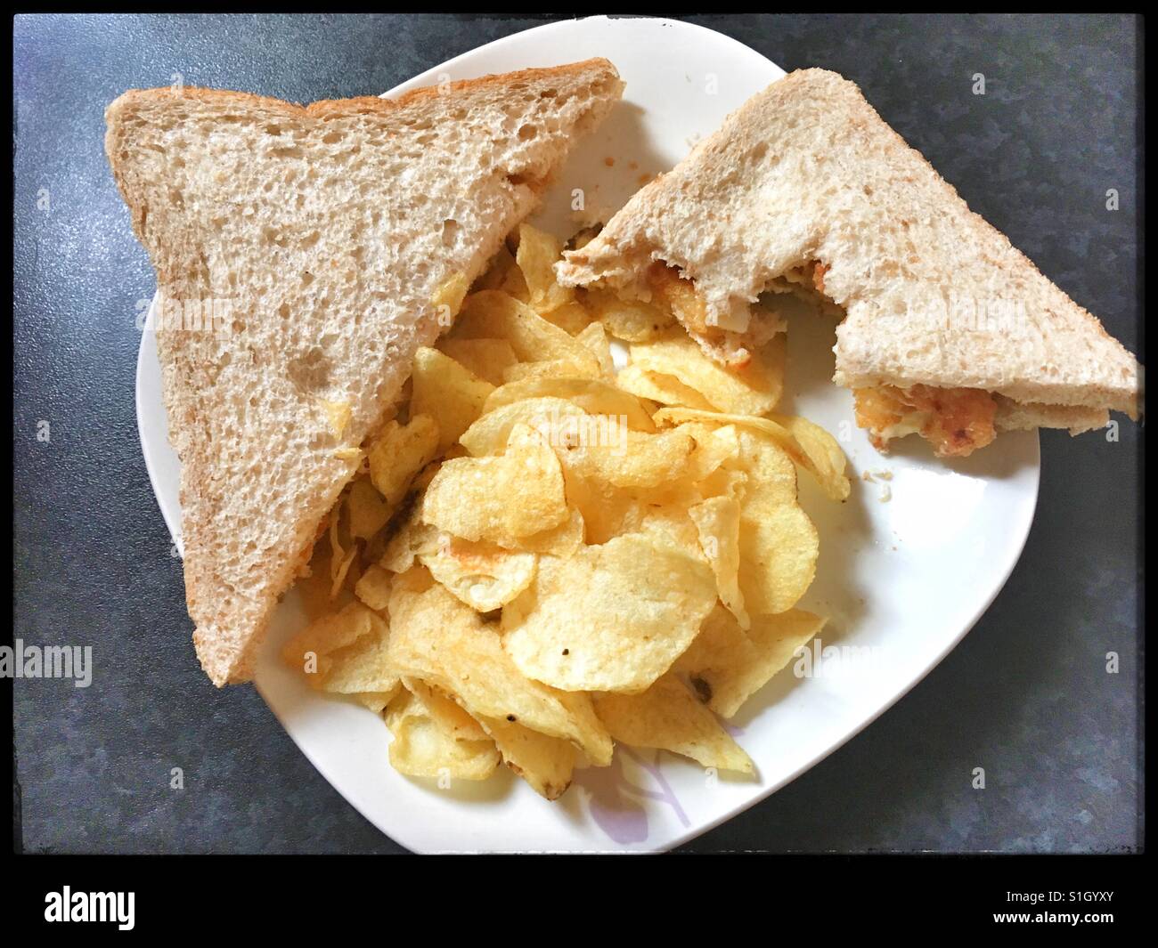 Halb gegessen Tintenfische Sandwich und Chips. Stockfoto