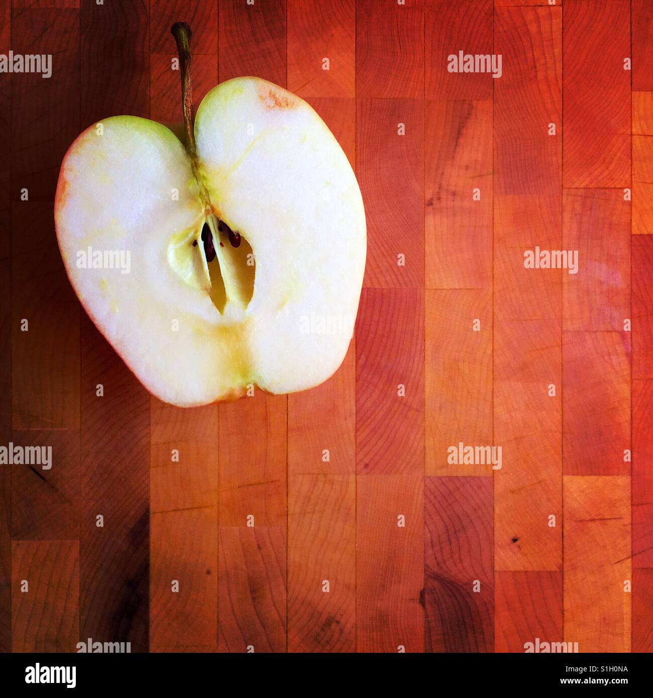 Die Hälfte eines Apfels auf einem Holzbrett Stockfoto