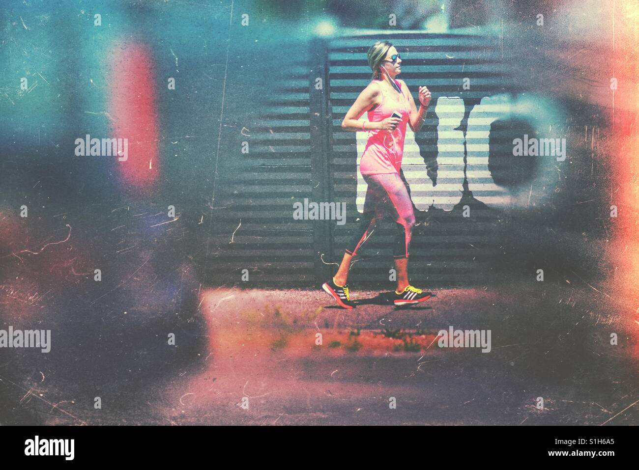 Sicher blond hochgewachsene junge Frau läuft in der Stadt - Smartphone-aufgenommenes Stockfoto