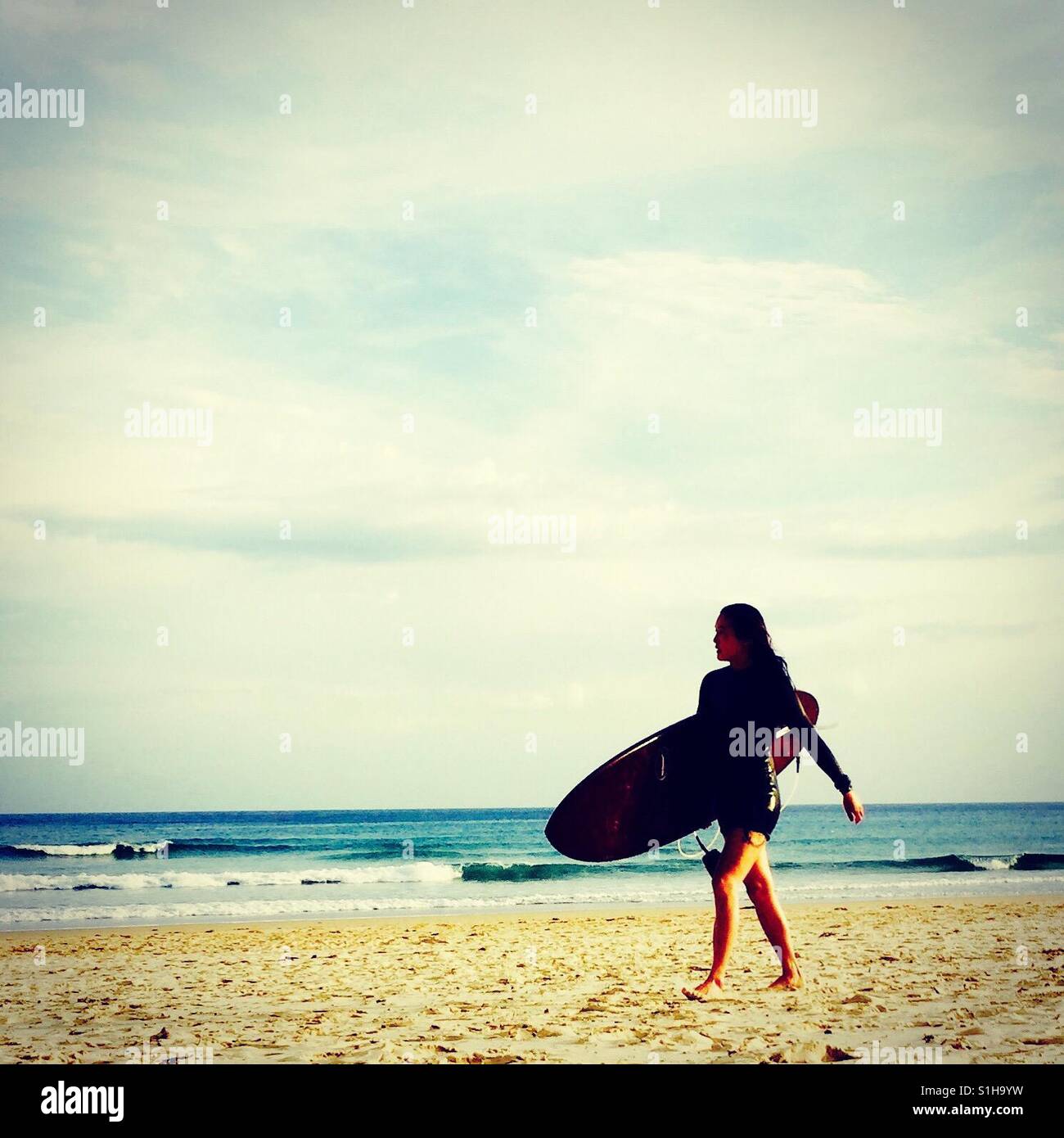 Australien, langen Surftag als Lebensstil, Mädchen zu Fuß mit dem Surfbrett auf den Sandstrand Stockfoto