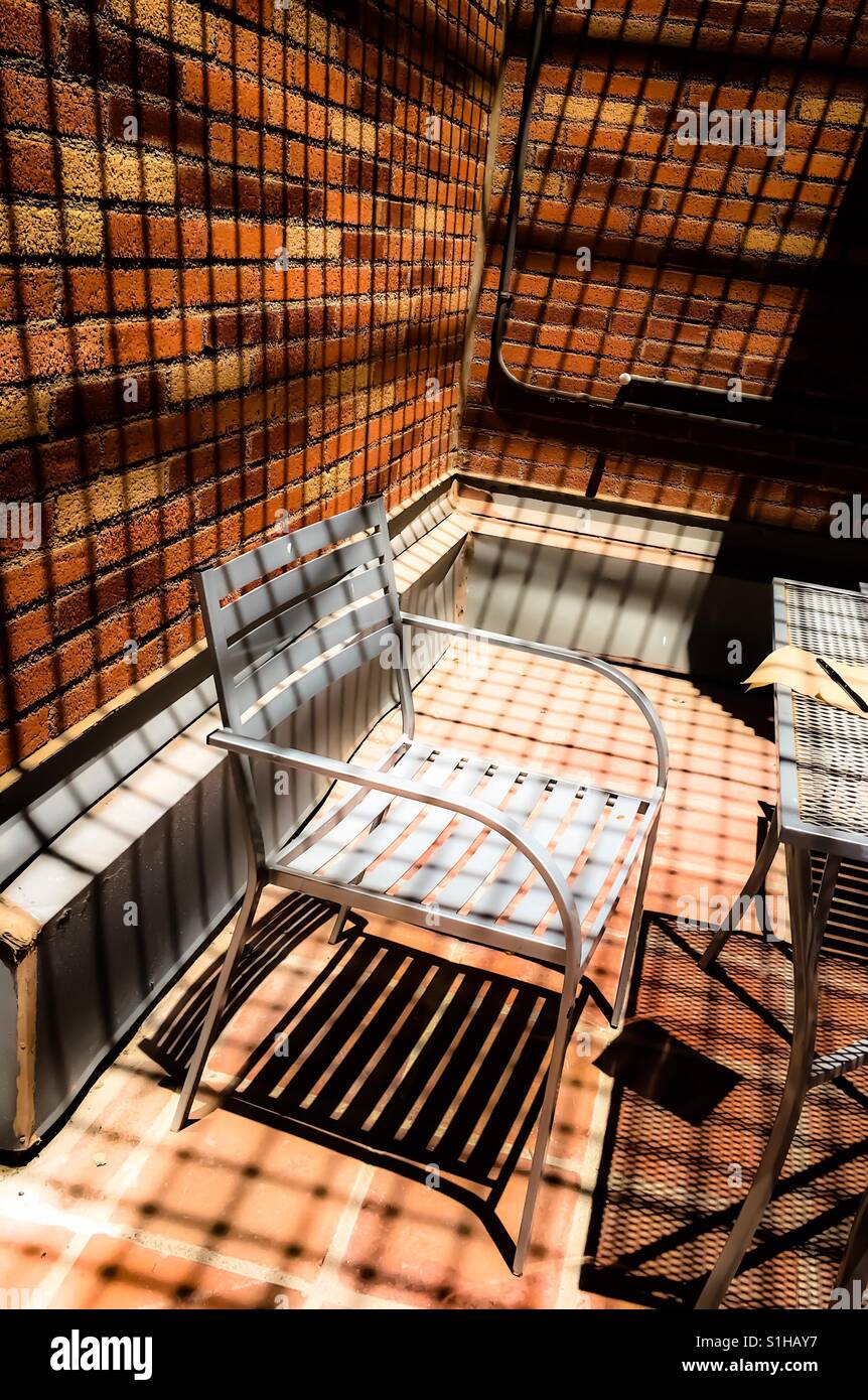 Einsame Stuhl in Linien und Schatten der surrealen Welt Stockfoto