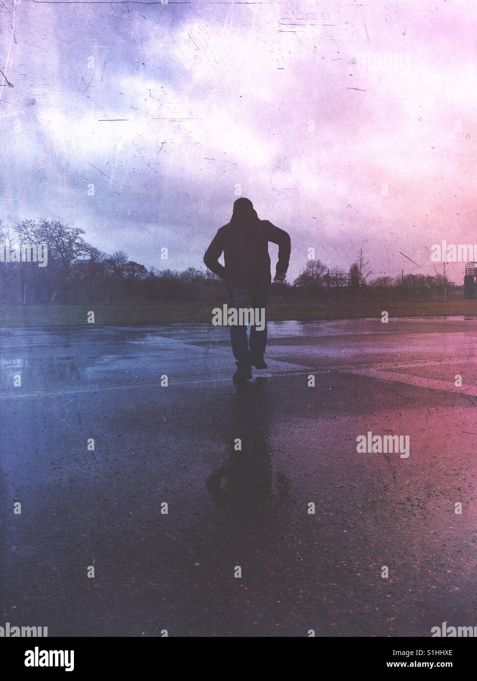 Rückansicht einer finsteren männlichen Figur weglaufen Stockfoto