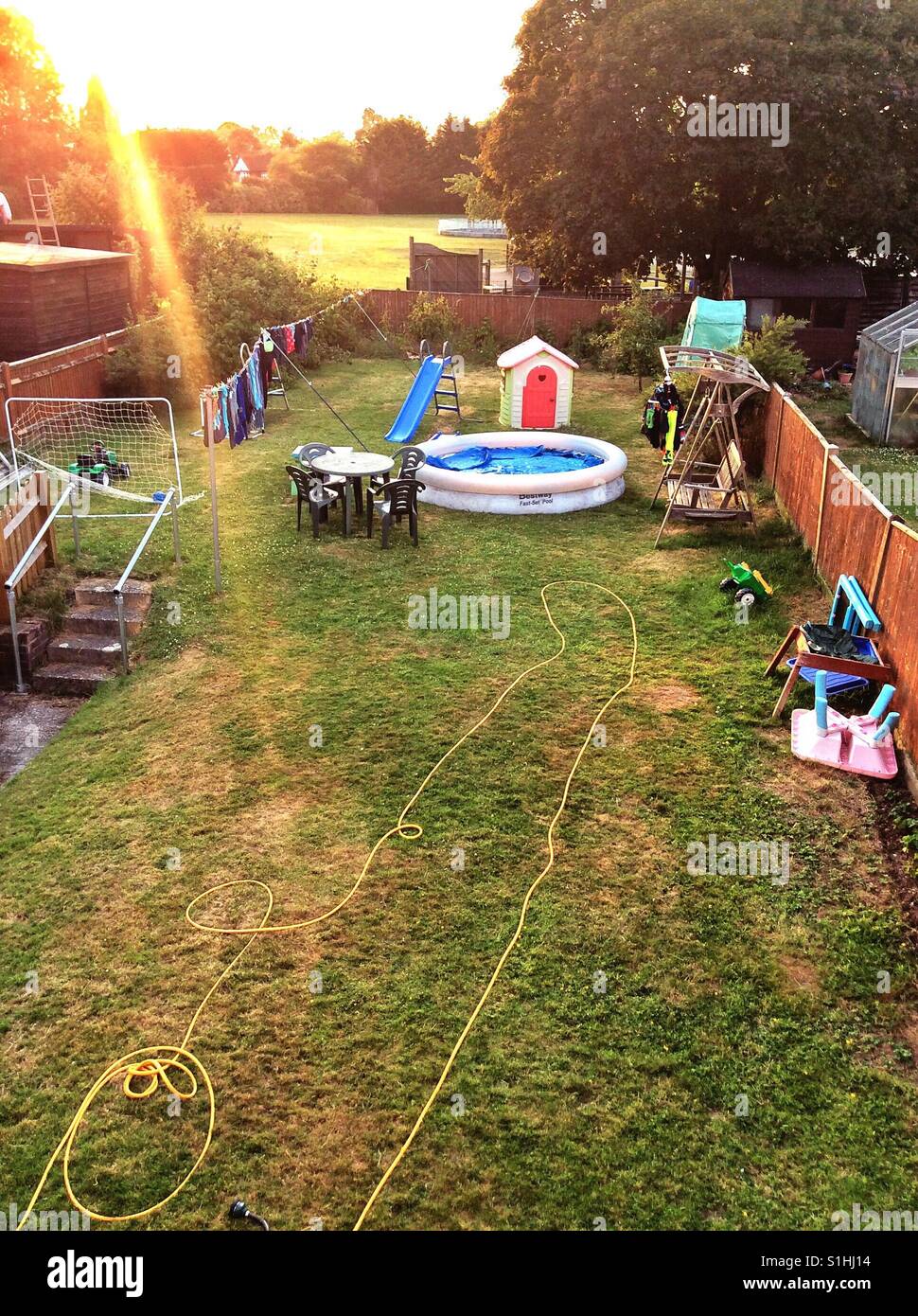 Blickte der Garten hinteren dem Haus von oben wie die Sonne beginnt zu sinken. Stockfoto