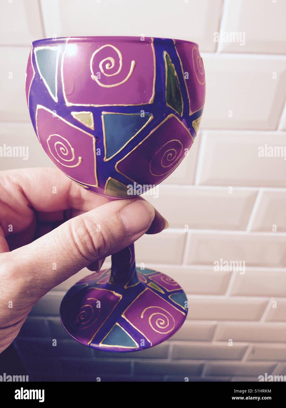 Prost! Hand mit bunten arty Weinglas - Smartphone-aufgenommenes Stockfoto
