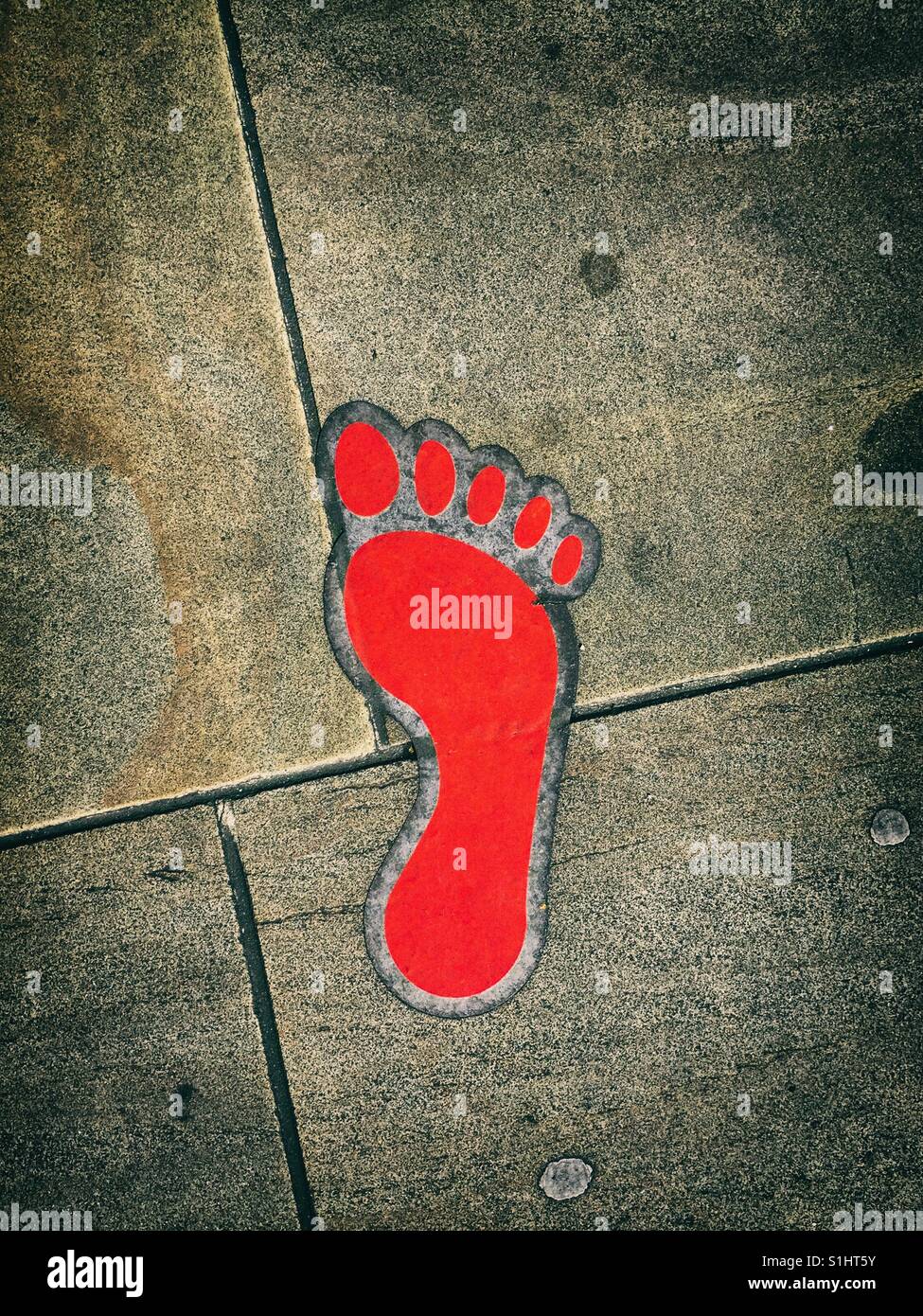 Rote Fußabdruck auf Bürgersteig Stockfoto