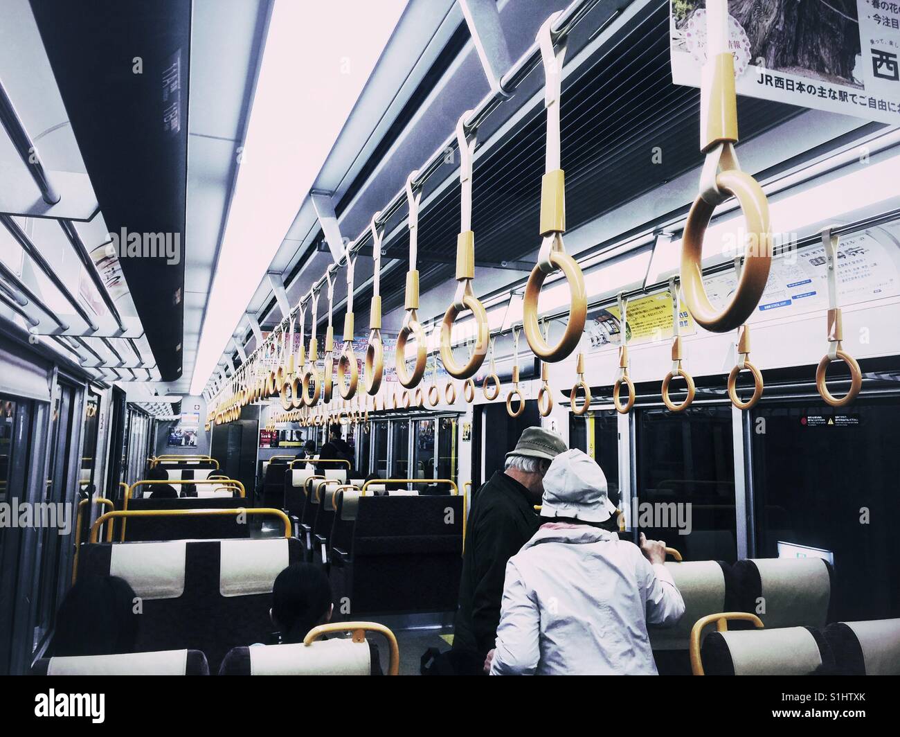 Älteren japanischen Ehepaar Wahl Sitze in leere Kyoto-u-Bahn Stockfoto