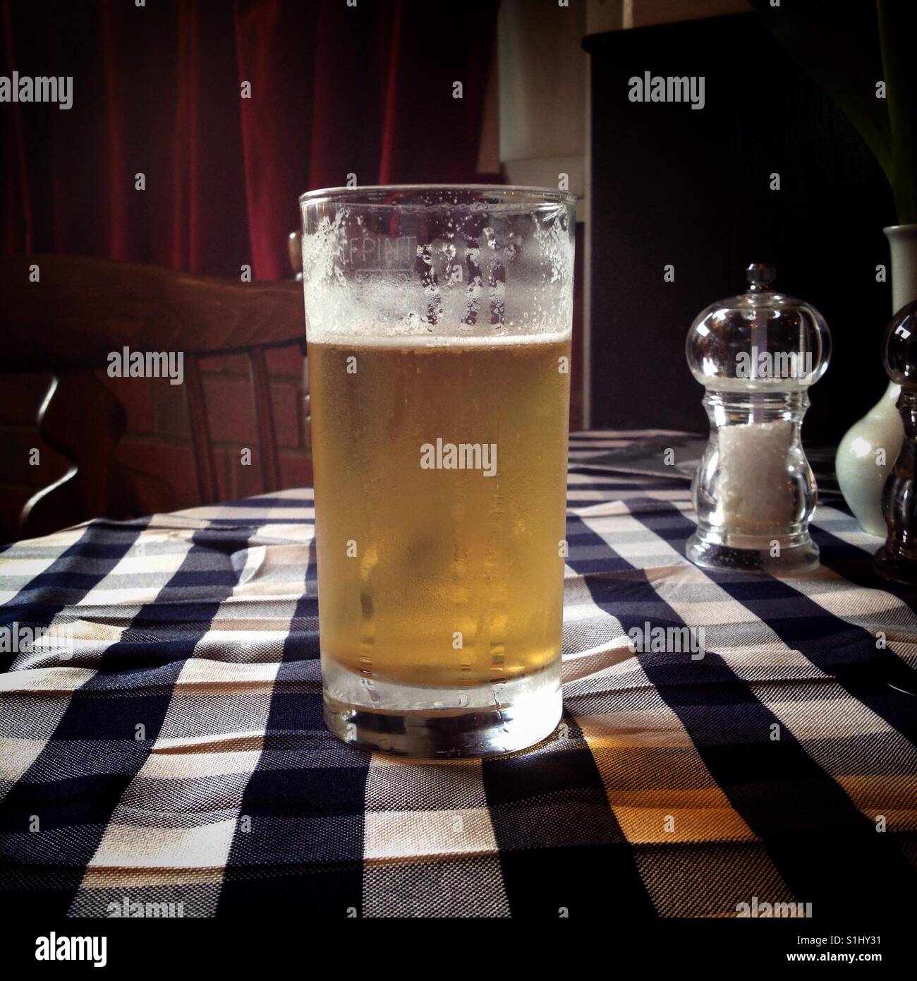 Half Pint Glas Lager auf Taverna Tisch Stockfoto