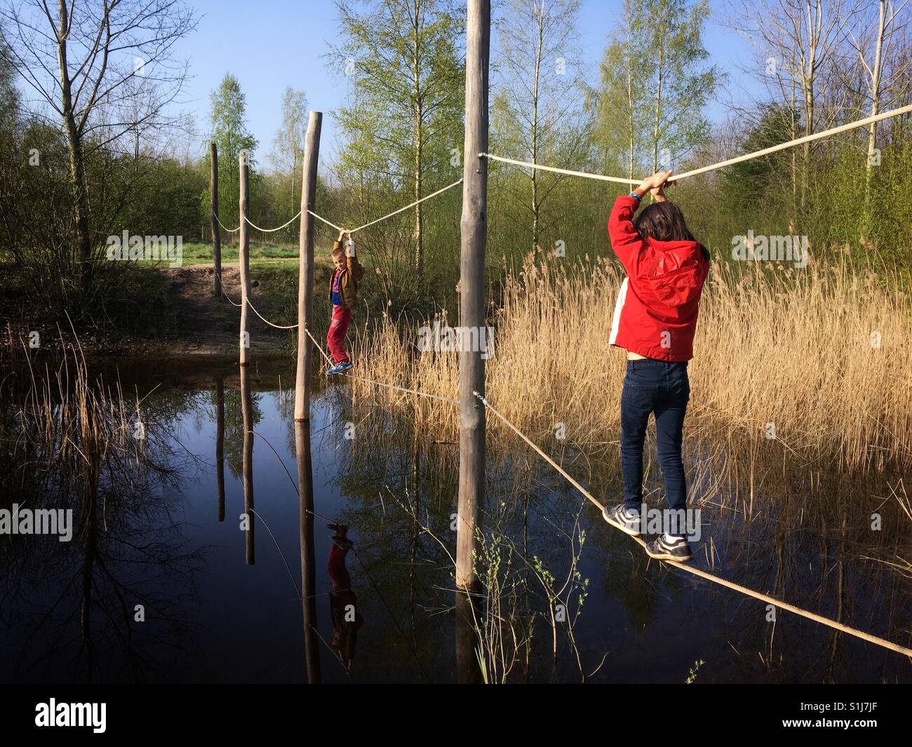 Zwei Kinder Wassersee in Seilen überqueren Stockfoto