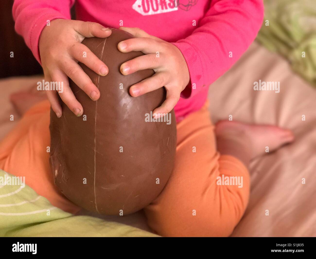 Kinder halten Schokoladen Osterei Stockfoto