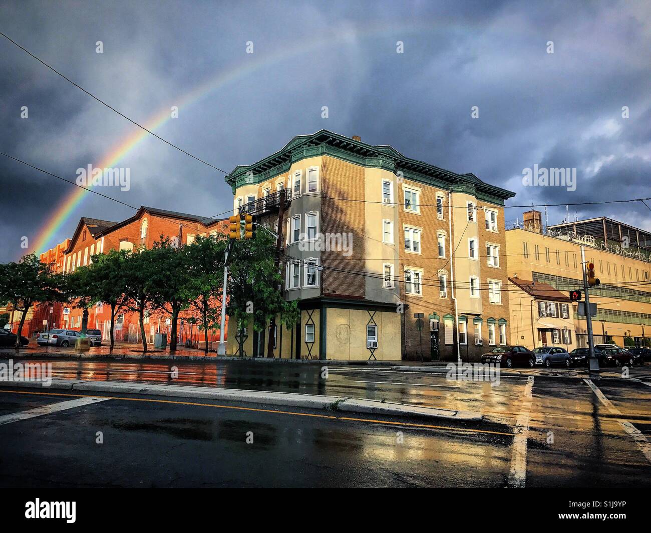 Regenbogen über Gebäude nach einem Starkregen Sturm Stockfoto