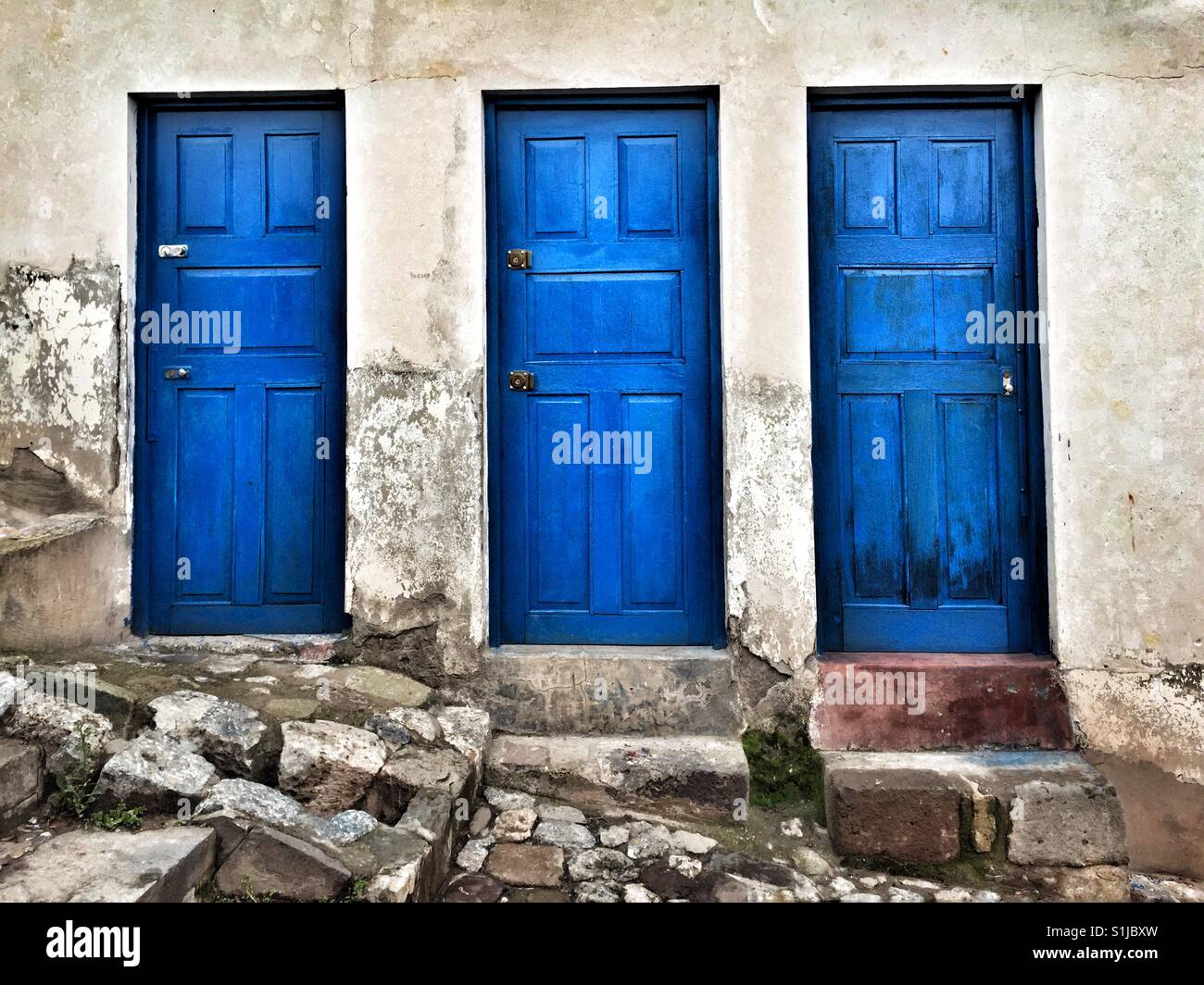 Baum Türen lackiert Kobaltblau in die weiße Wand in Cusco-Peru Stockfoto