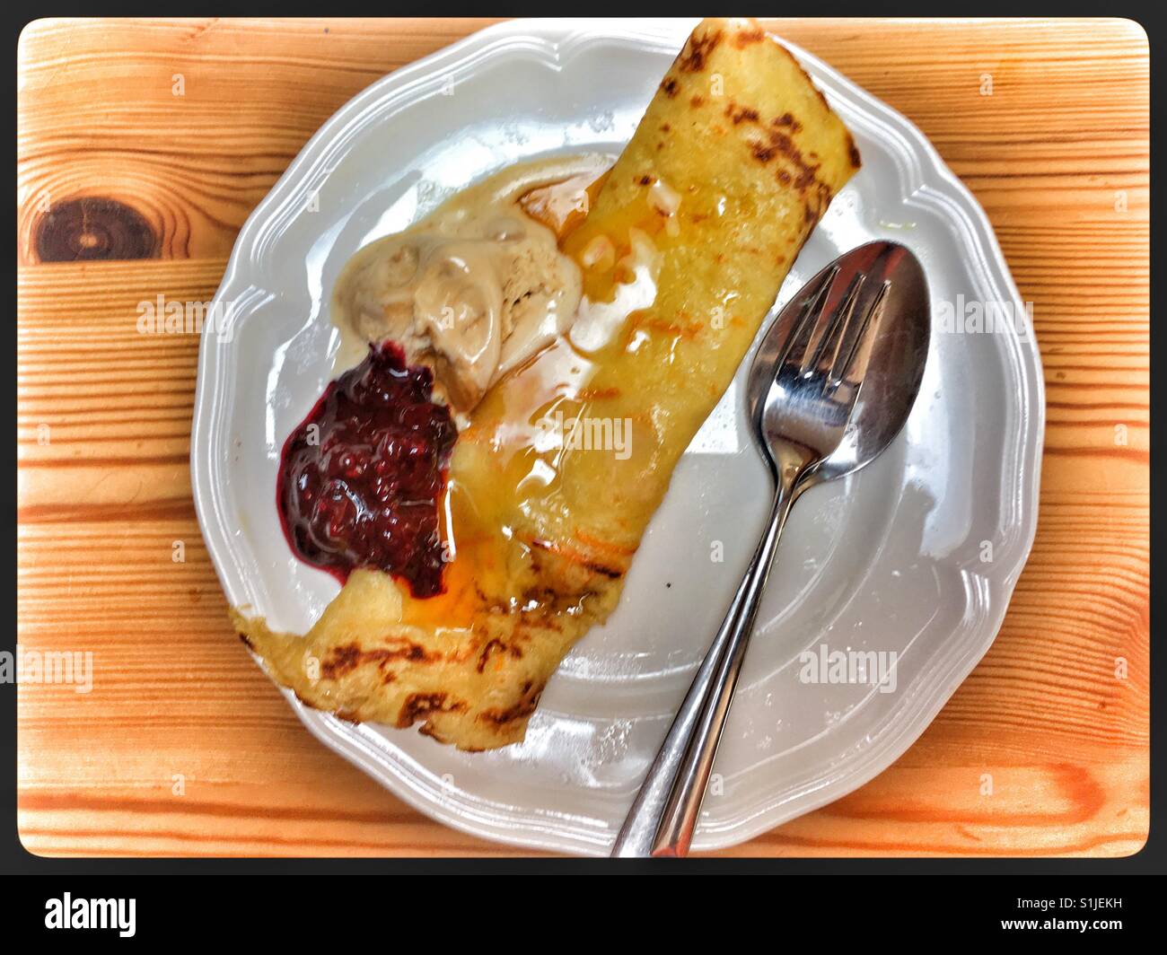 Orange Pfannkuchen mit Sirup, Butterscotch Eis und eine rote Johannisbeere Reduktion. Stockfoto