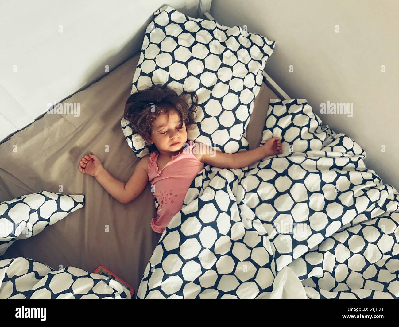 Litttle Mädchen schlafend auf einem großen Bett Stockfoto