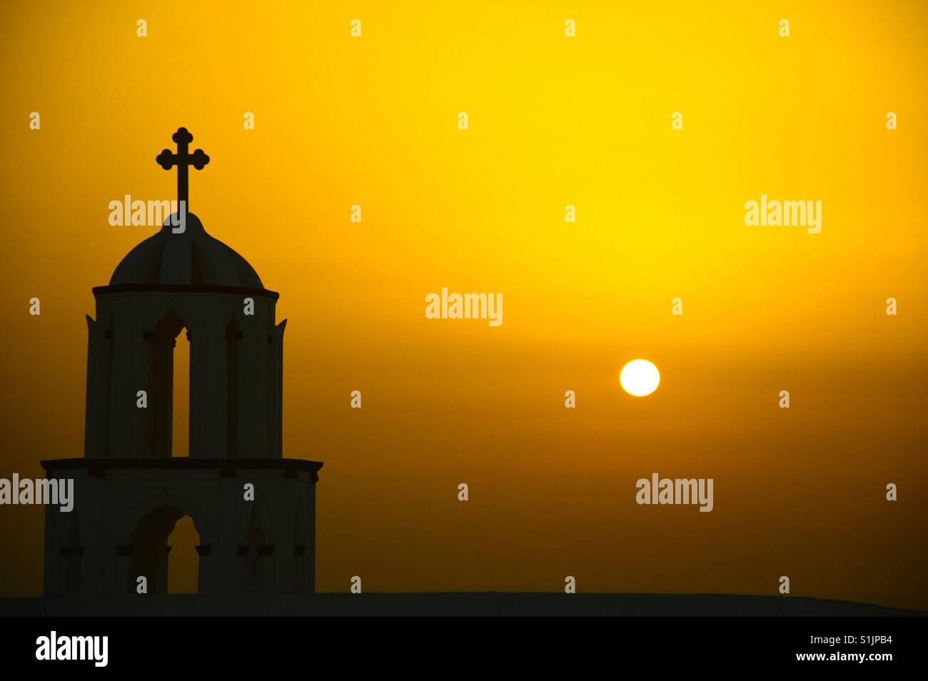 Silhouette einer orthodoxen Kirche bei Sonnenuntergang in Santorini Stockfoto