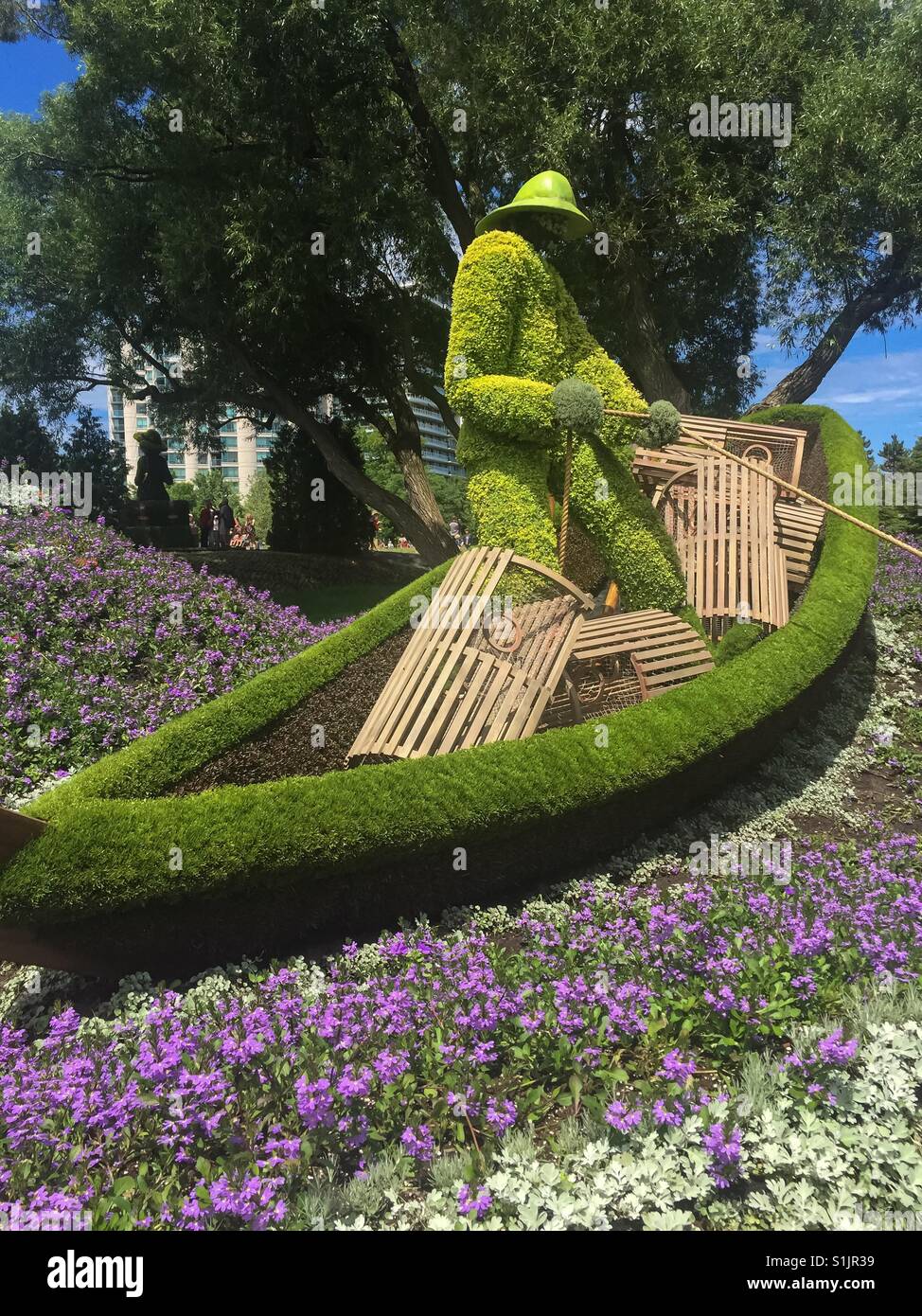 Kanufischer: Skulptur in Pflanzen und Blumen. Eine Nachbildung einer legendären kanadischen Szene. Traditionell und modern. Stockfoto