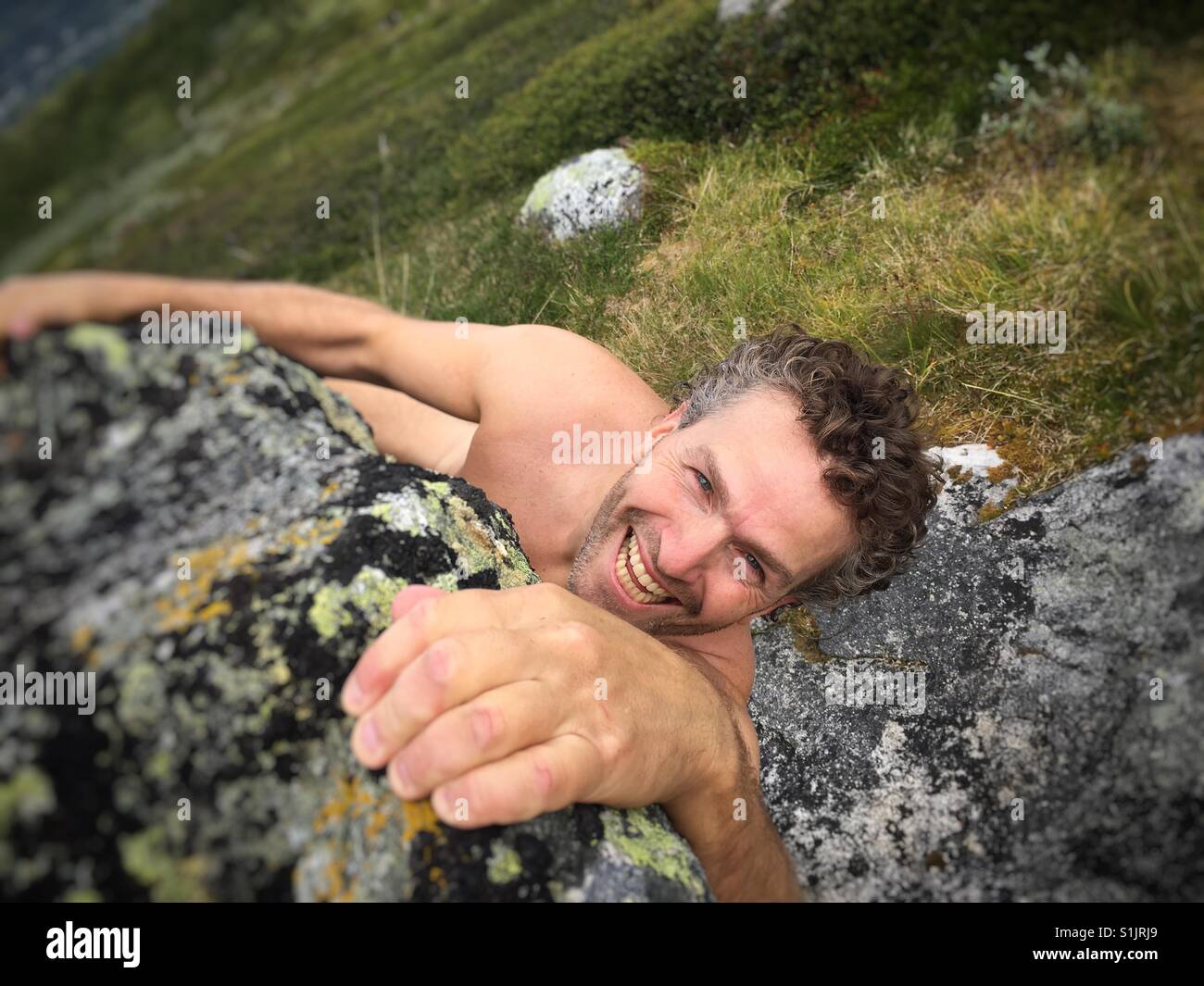 Der nackte Kletterer Bouldern auf einem großen Felsen im Nationalpark Hardangervidda, Norwegen. Stockfoto