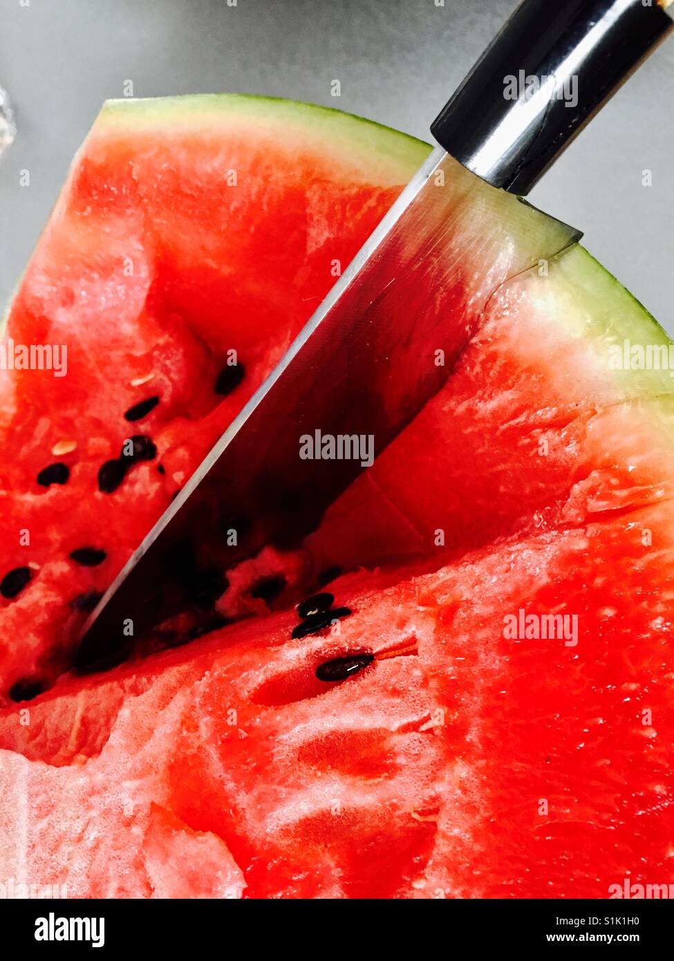 Messer in Wassermelone Stockfoto