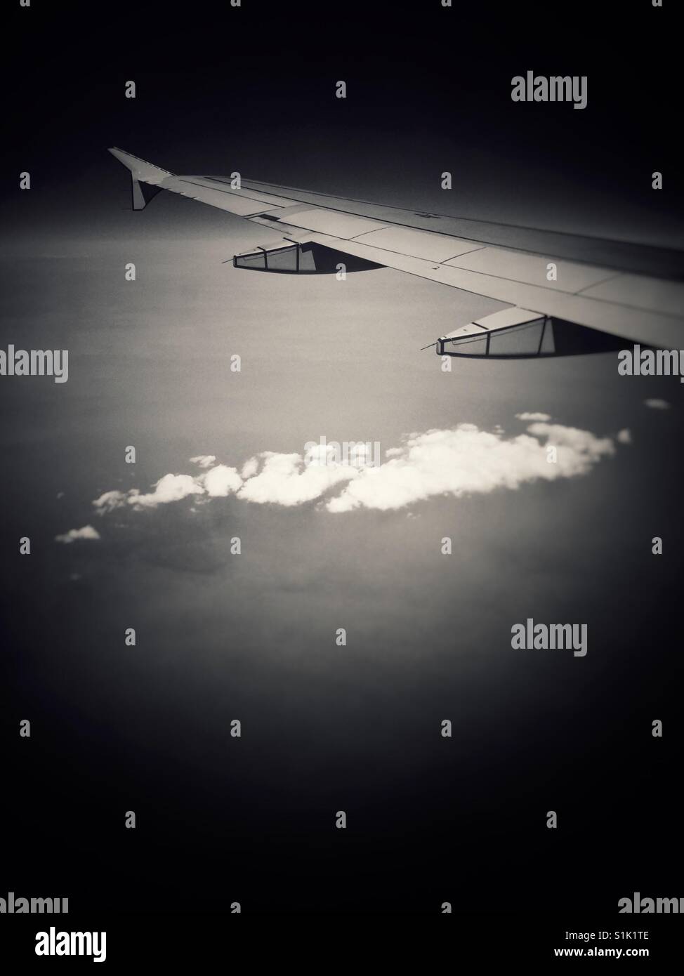 Jet Tragfläche über einzelne Wolke und rauchigen Himmel. Stockfoto