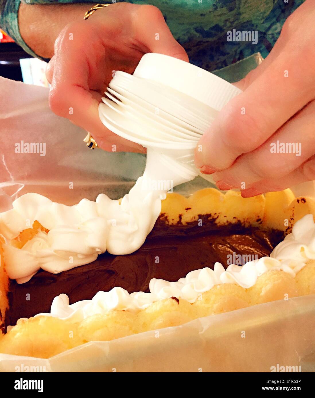 Koch Anwendung Schlagsahne Sahnehäubchen zu desertieren. - Smartphone-aufgenommenes Stockfoto