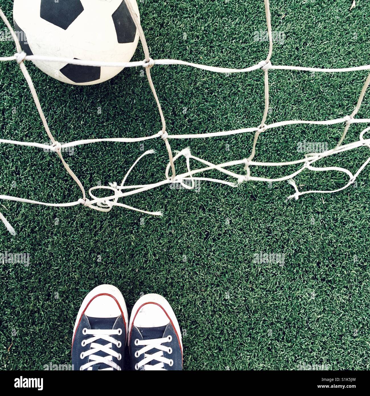 Fußball auf dem Feld und Füße Stockfoto