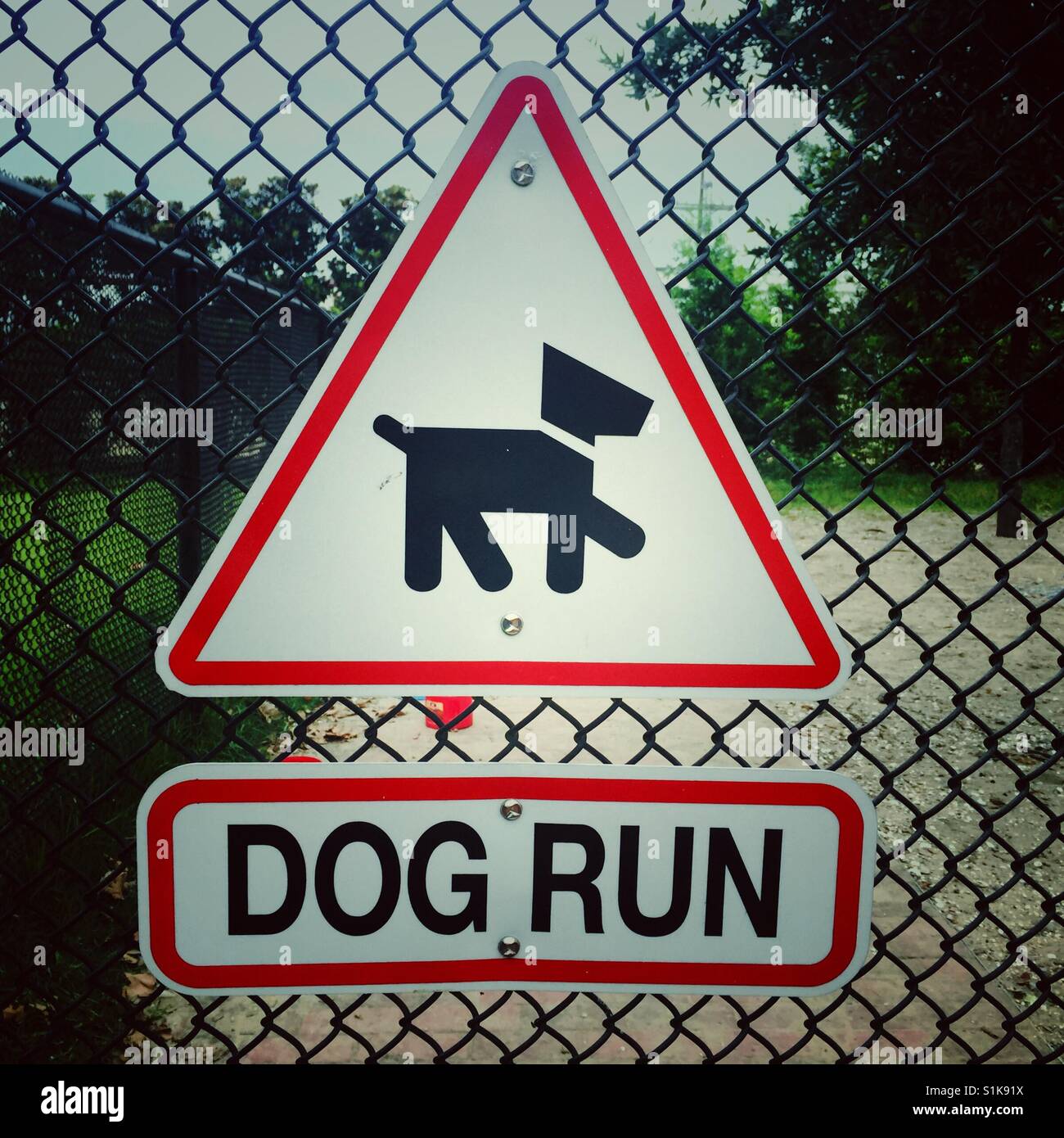 Dreieck-Zeichen mit Bild des Hundes und Schild mit Worten Hundeauslauf beigefügten, Maschendrahtzaun Stockfoto