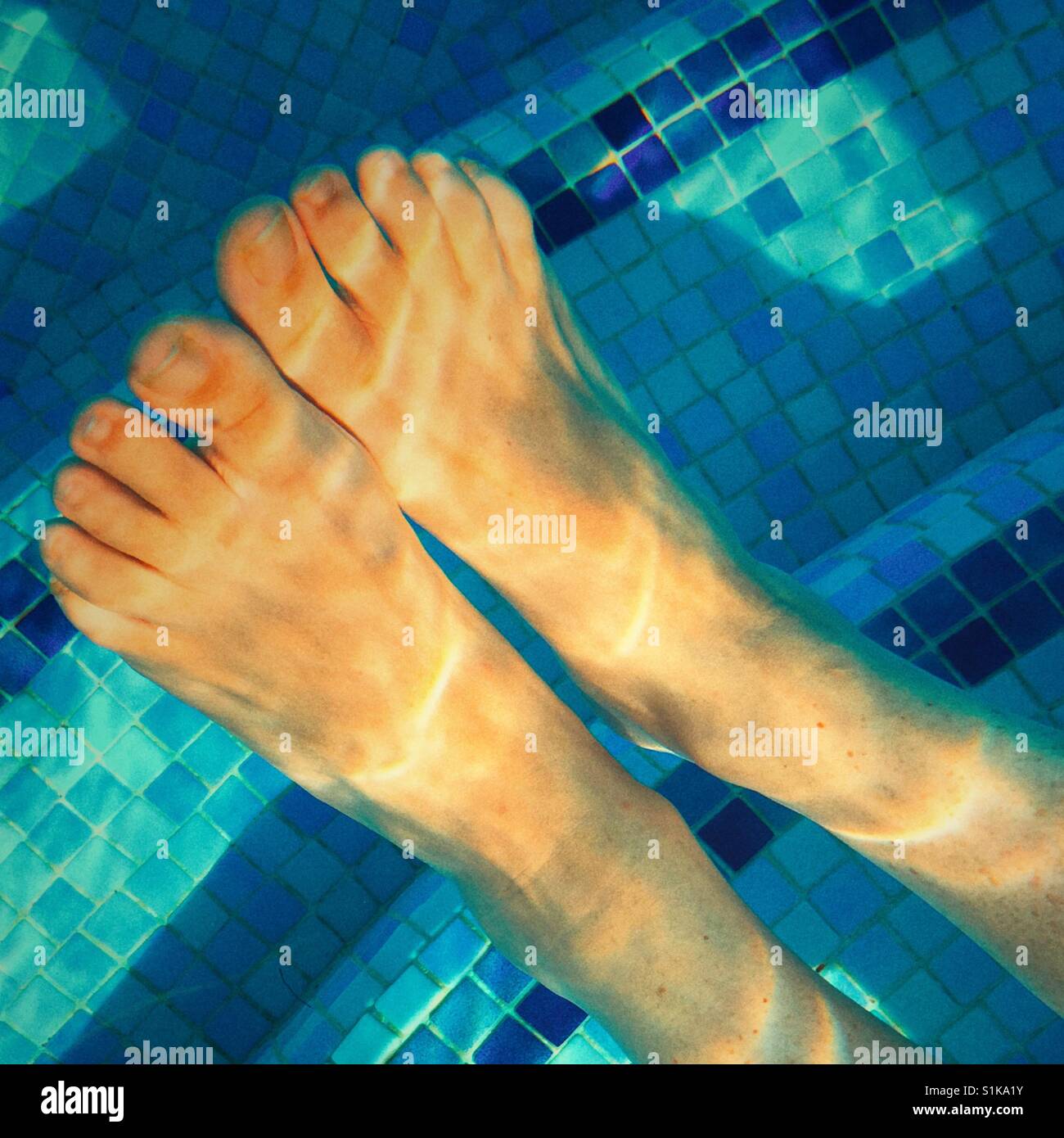 Kühl zu halten. Füße in einem Schwimmbad Stockfoto