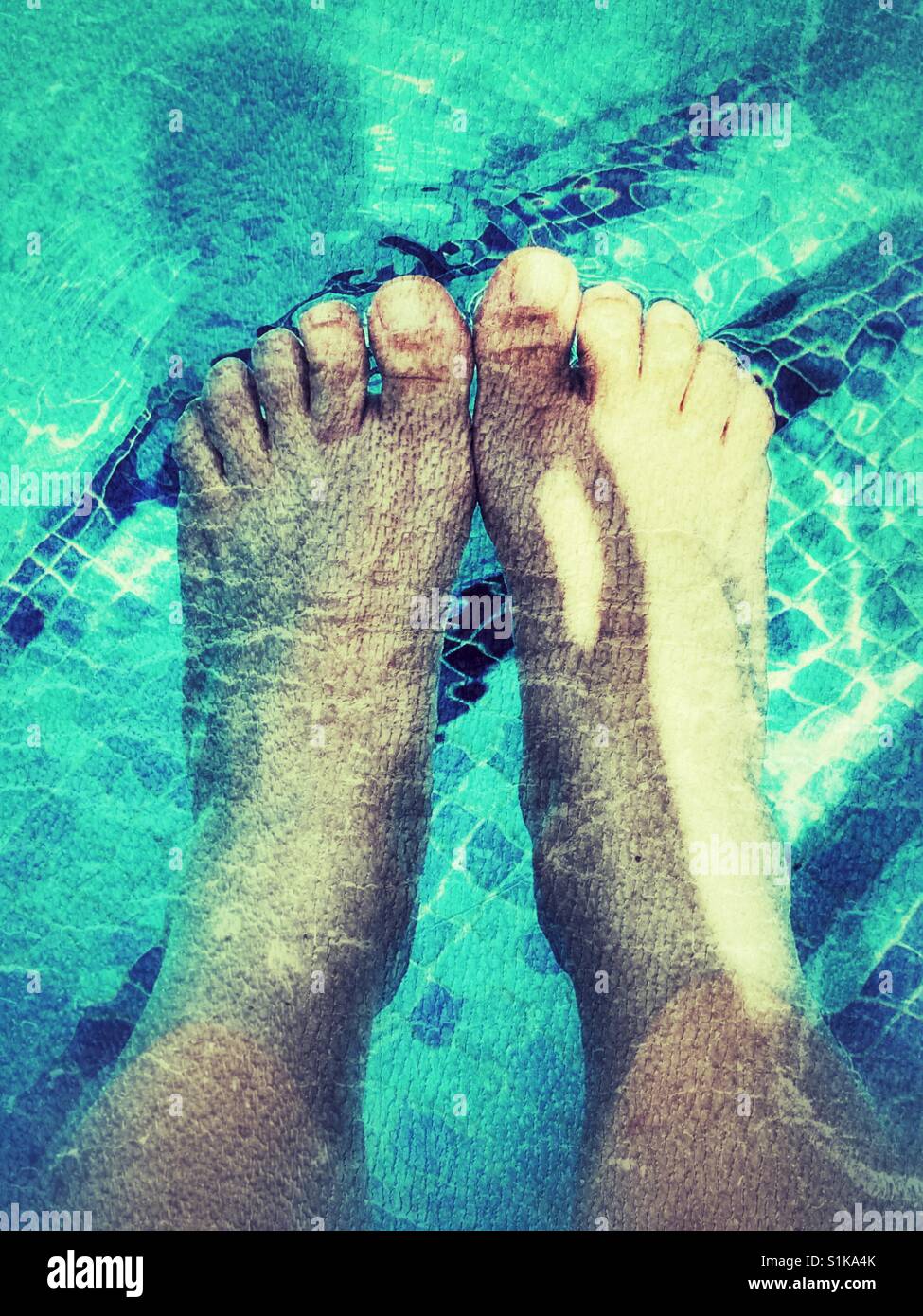 Füße im Pool. POV. - Smartphone-aufgenommenes Stockfoto
