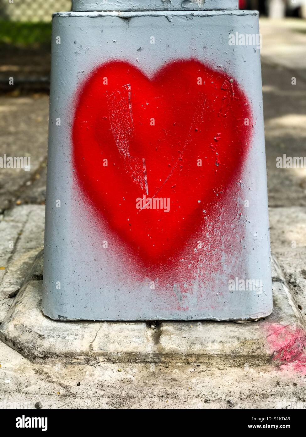 Herz Graffiti gemalt auf ein Straßenschild. - Smartphone-aufgenommenes Stockfoto
