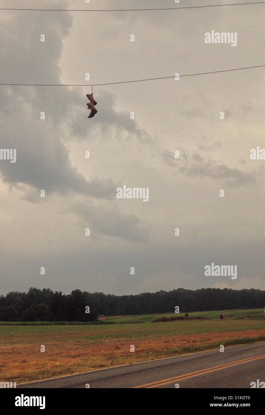Stiefel im Wind-Sturm bewegt sich in Stiefel hängen Stromleitung auf Bauernhof in North Carolina Stockfoto