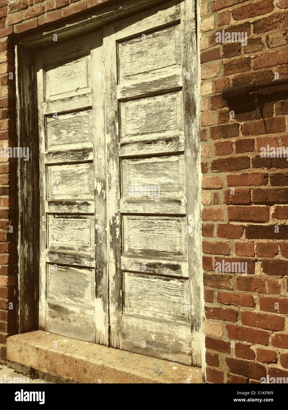 Chippy weißen Flügeltüren auf gemauerten Gebäude - North Carolina Stockfoto