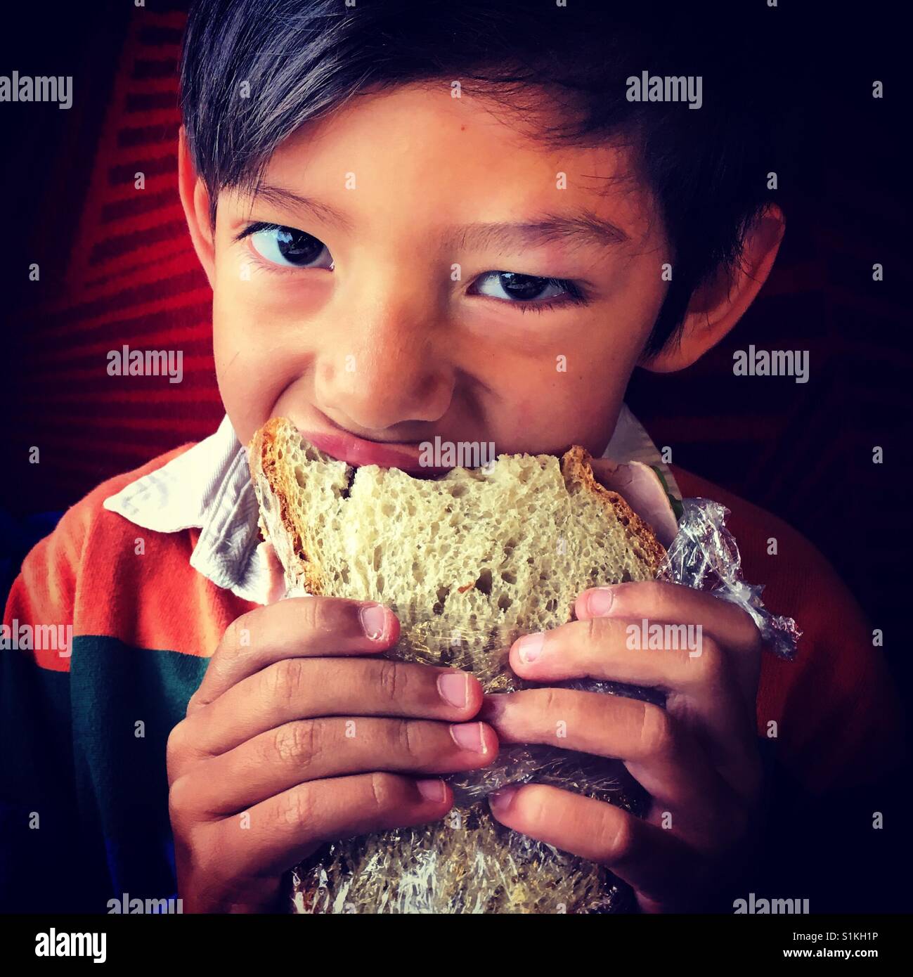Lustiges Gesicht Kind essen sandwich - Smartphone-aufgenommenes Stockfoto