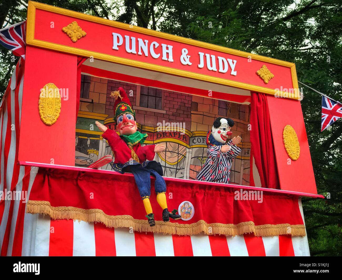Herr Punch & Joey der Clown. Ein klassisches Open-Air Theater Kindershow, als Teil von The Punch & Judy Show. Es ist Sommer und Zeit für Kinder, sich zu amüsieren! Bildnachweis - © COLIN HOSKINS. - Smartphone-aufgenommenes Stockfoto