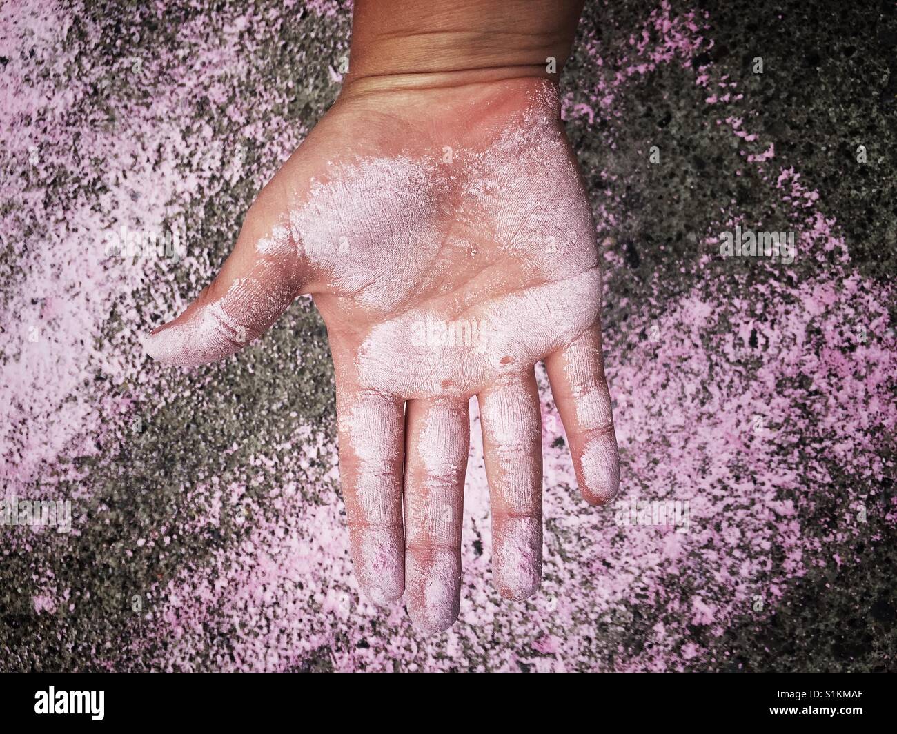 6 Jahre altes Kind Hand mit rosa Kreide beschmiert Stockfoto