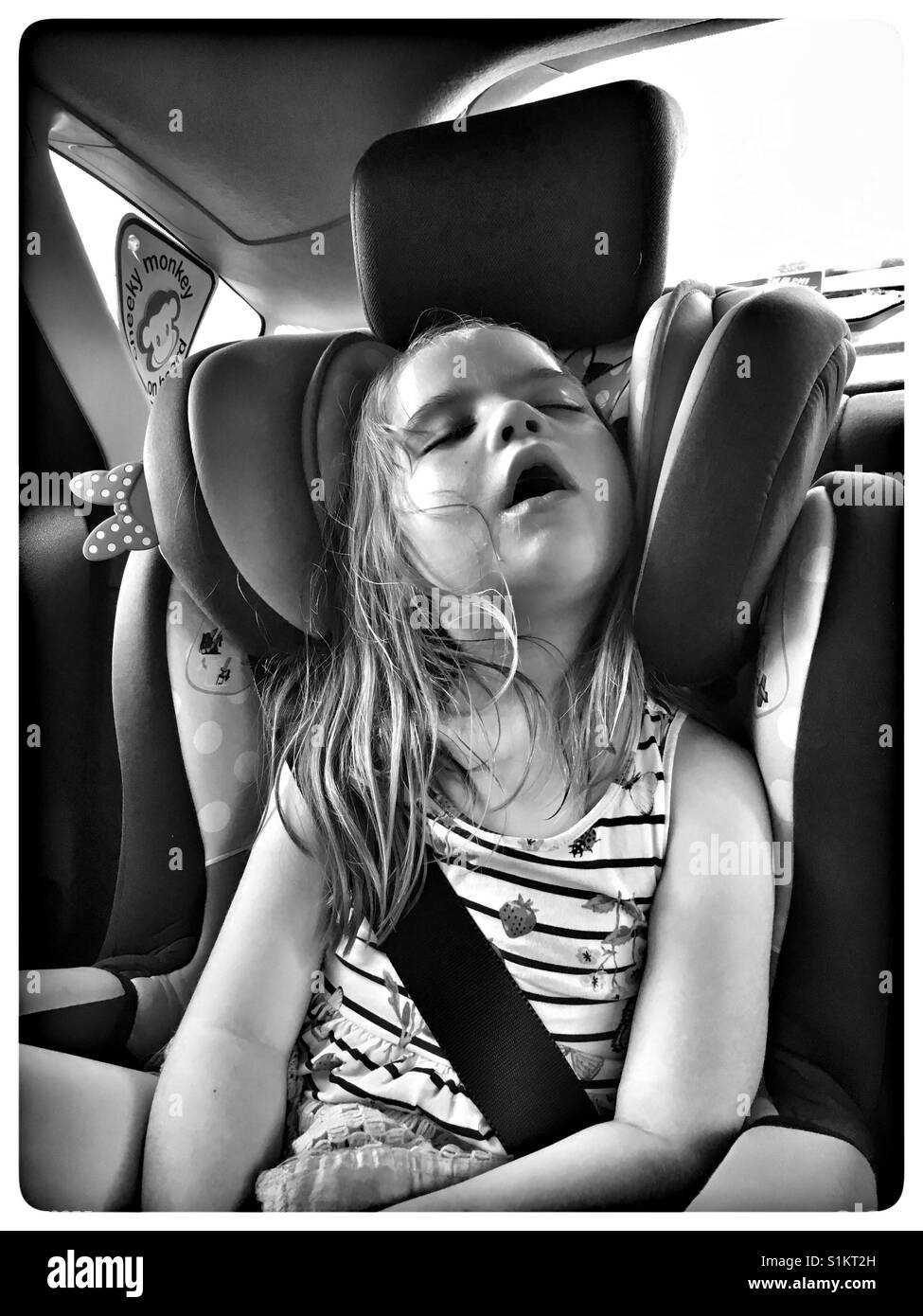 5 Jahre altes Mädchen schlafen in einem Autositz. Stockfoto