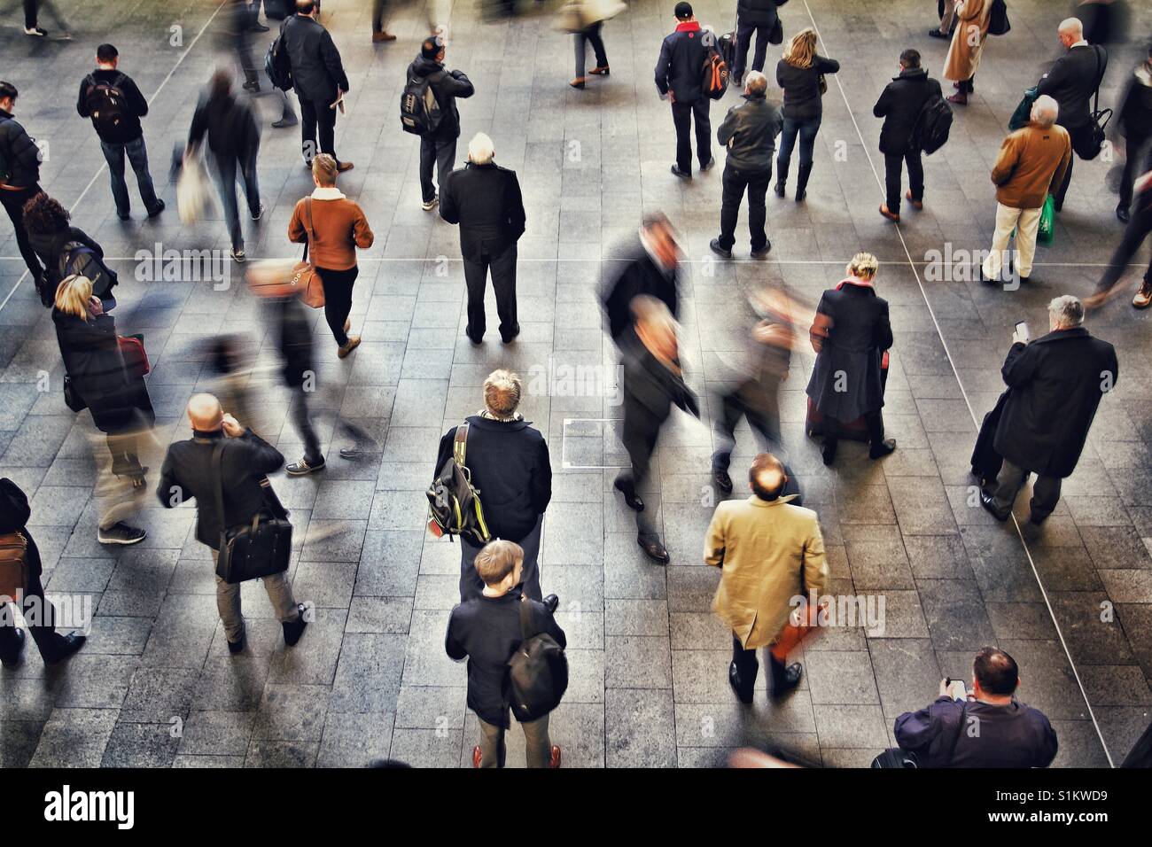 Pendler, Fahrgäste und Reisende warten auf einen belebten Bahnhofshalle um Rush Hour oder Peak-Zeit warten und rauschenden für ihren Transport. - Smartphone-aufgenommenes Stockfoto