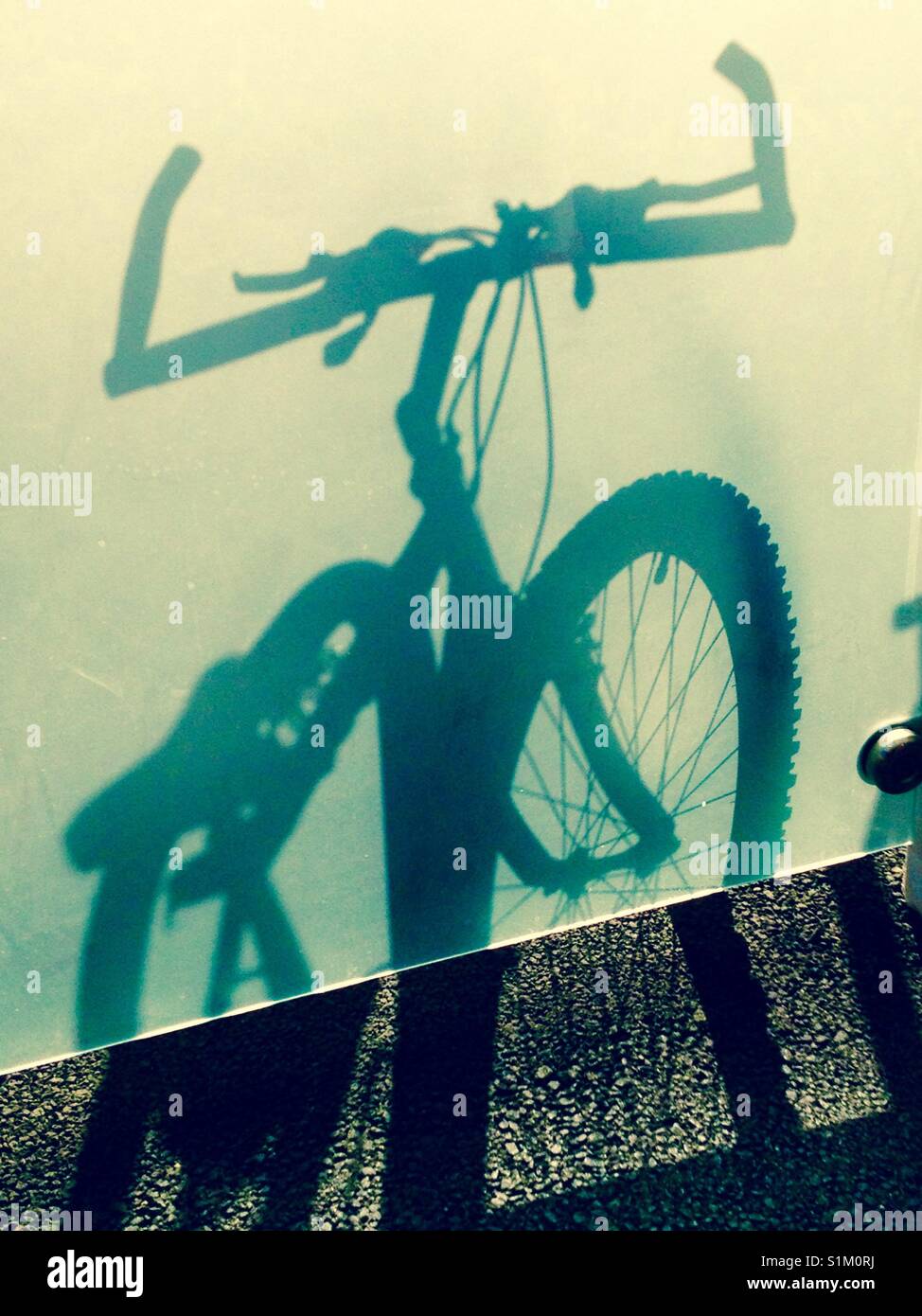 Shadow/Silhouette eines Fahrrad auf/hinter Milchglas. Großbritannien Stockfoto