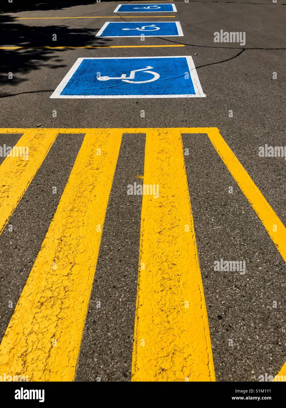 Drei rollstuhlgerechte Parkplätze im Freien. Blaue und weiße Markierungen. Schablone - Smartphone-aufgenommenes Stockfoto
