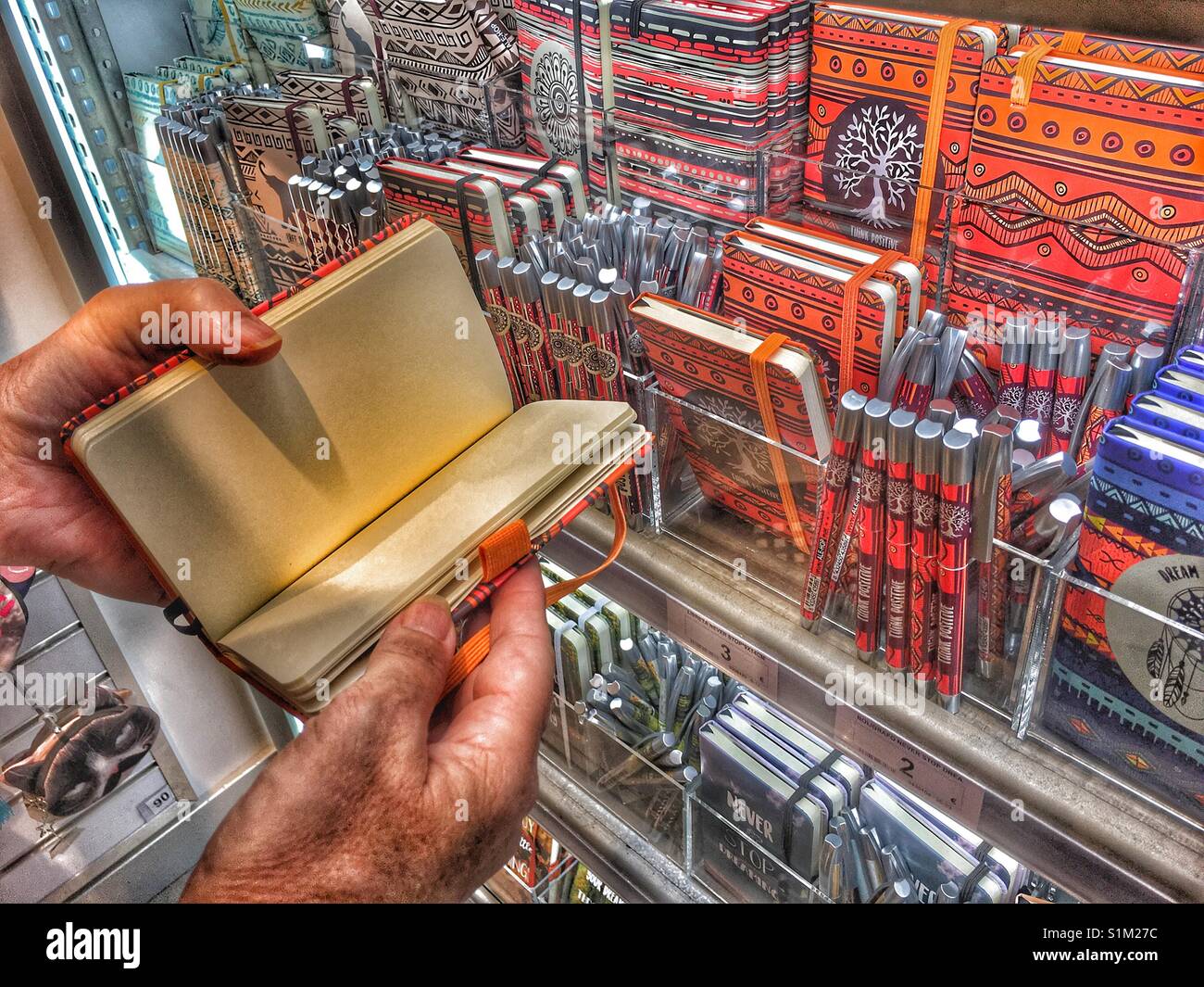 Frau auf der Suche nach Notebooks in einem Ale-Hop Shop - Smartphone-aufgenommenes Stockfoto