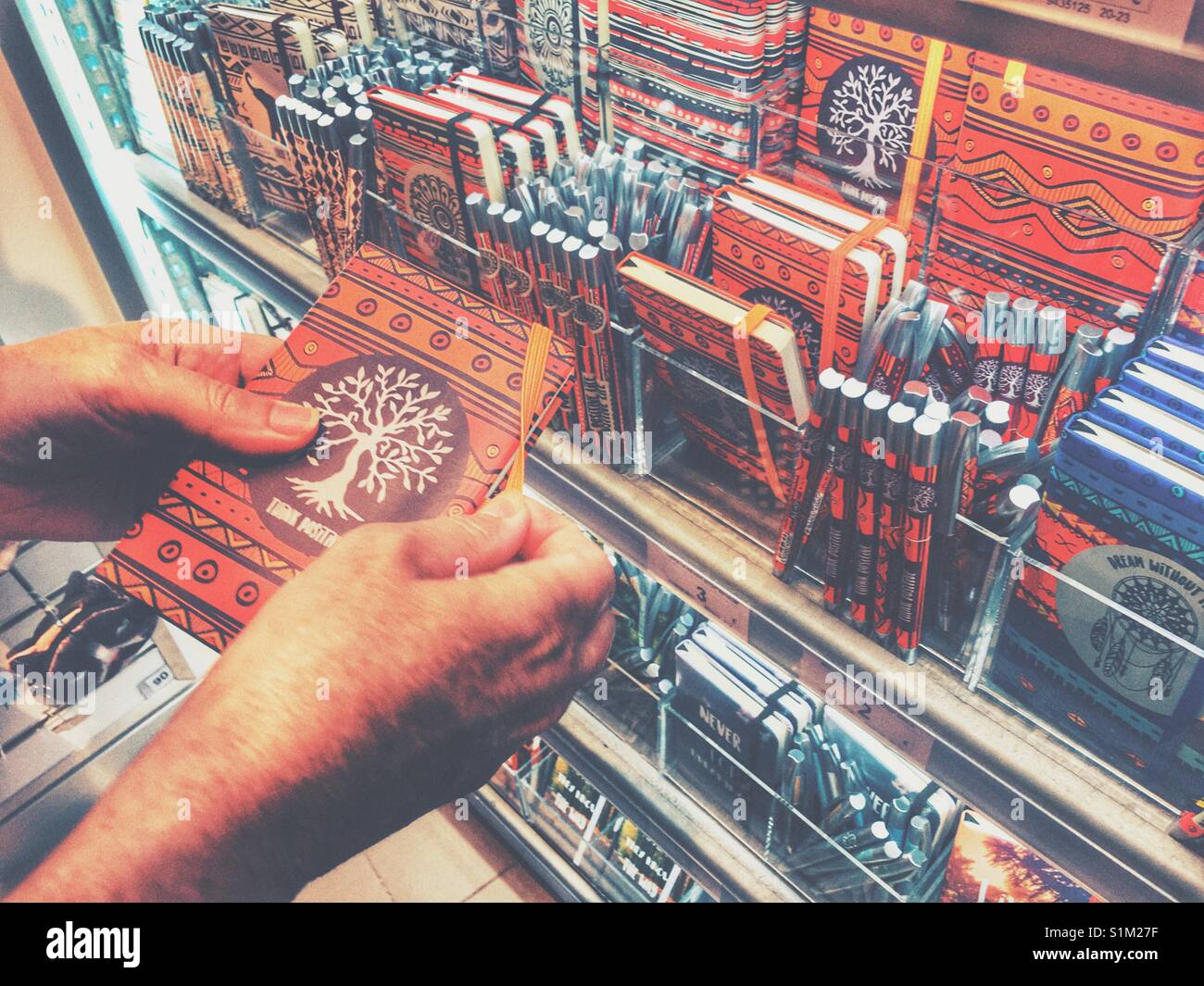 Frau auf der Suche nach Notebooks in einem Ale-Hop Shop Stockfoto