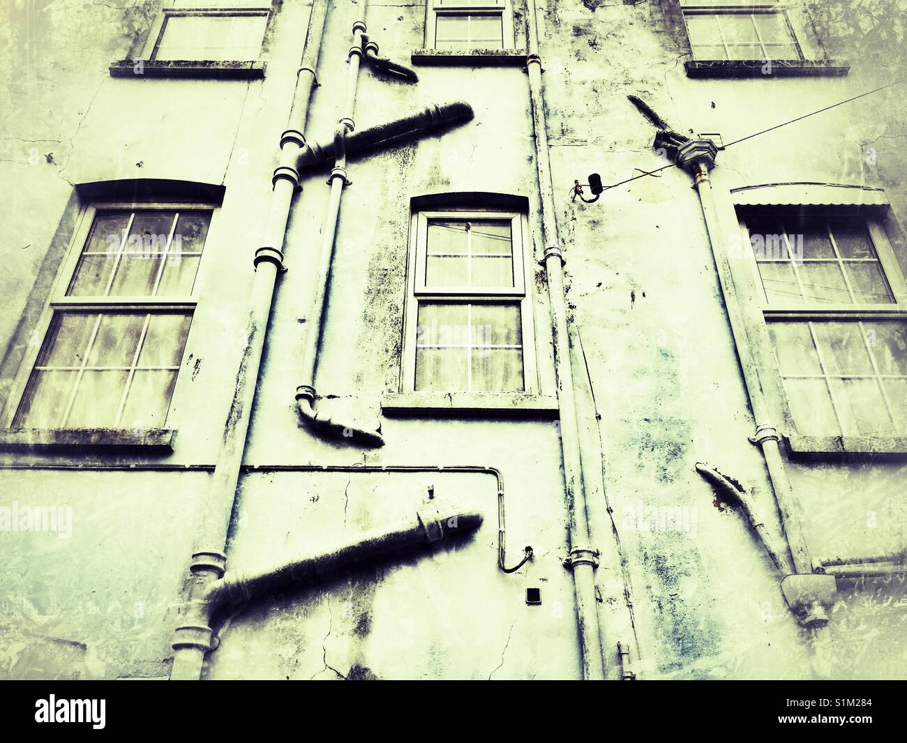 Abwasserleitungen auf der Seite von Apartment Block - Smartphone-aufgenommenes Stockfoto