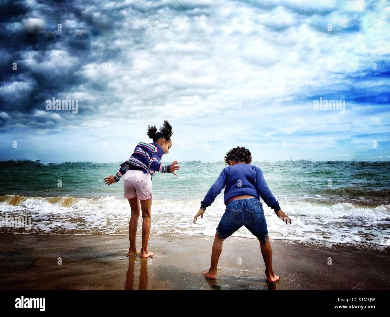 Zwei Kinder spielen am Strand. Stockfoto