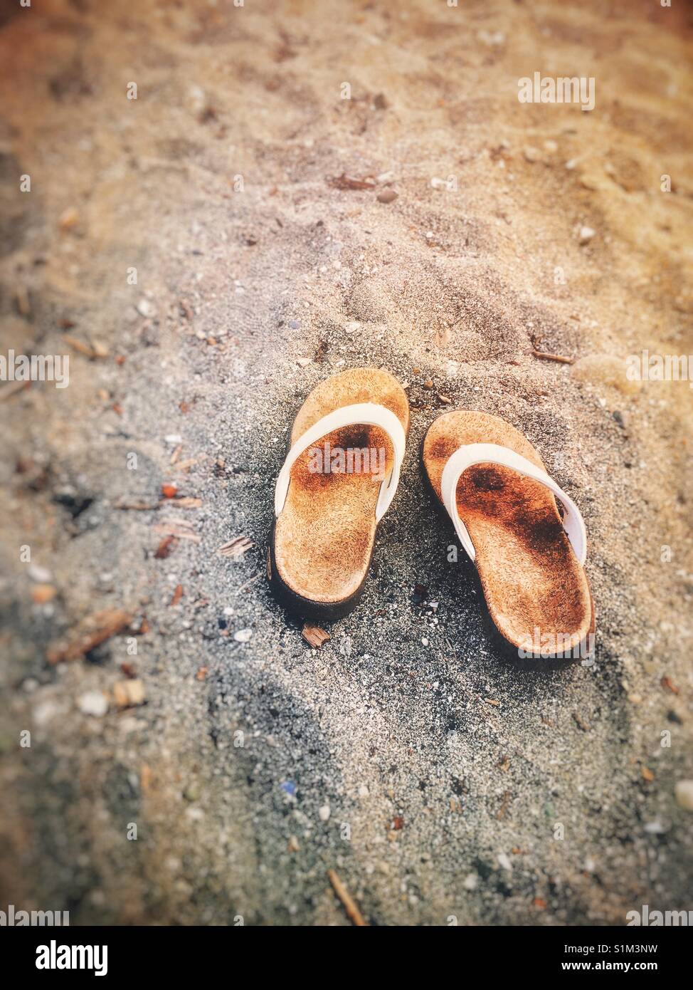 Weißen Stoff und Kork Sohlen Flip-Flop-Sandalen im Sand. Stockfoto