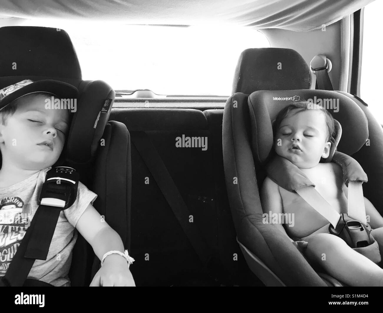 Vorschüler und Baby schlafend in einem Auto. Stockfoto