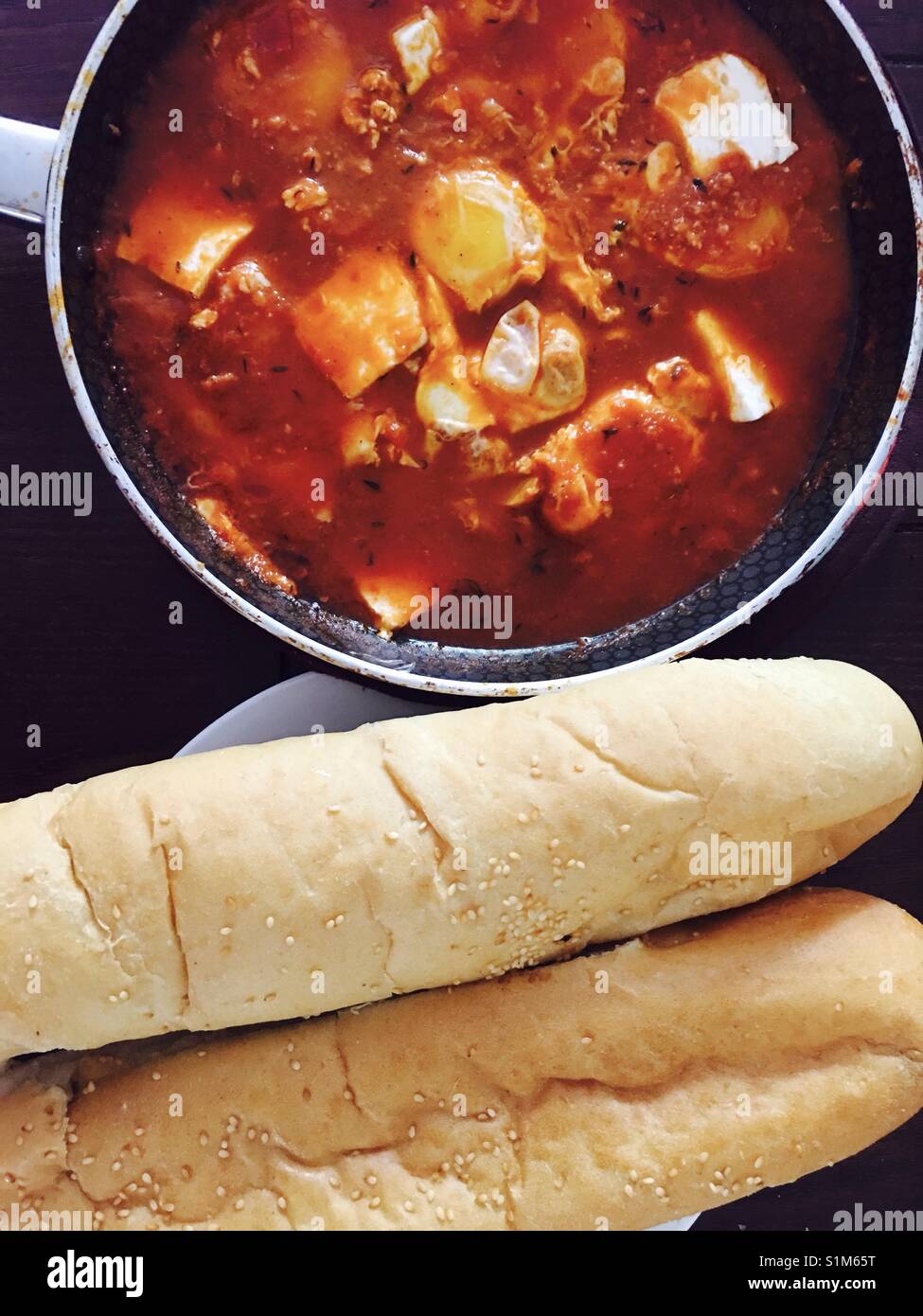 Shakshuka - einen tunesischen Stil Eierspeise mit frischem Brot serviert. Stockfoto