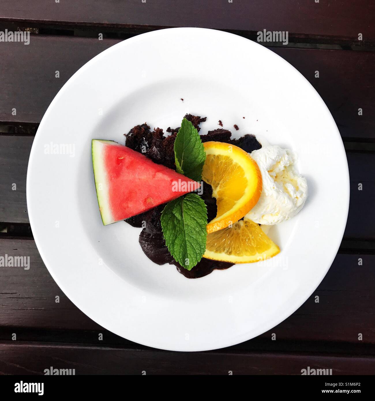 Schokolade Kuchen mit Früchten und Eis serviert. - Smartphone-aufgenommenes Stockfoto