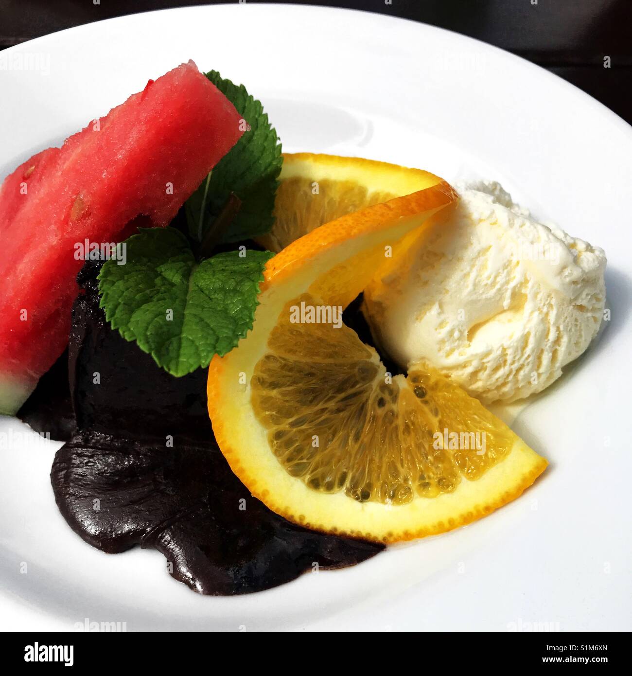Schokolade Kuchen mit Früchten und Eis serviert. - Smartphone-aufgenommenes Stockfoto