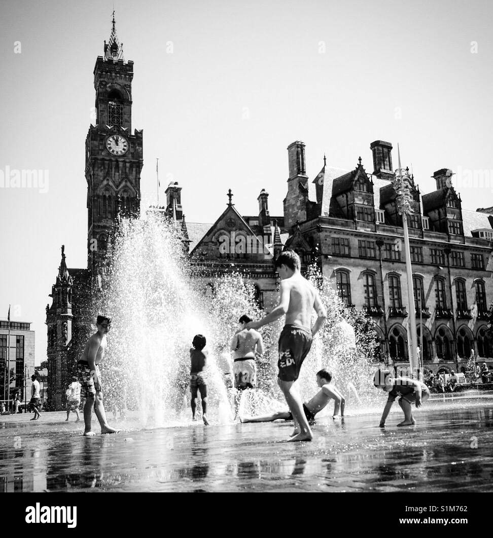 Kinder im Wasser Brunnen in Bradford, West Yorkshire, England. - Smartphone-aufgenommenes Stockfoto