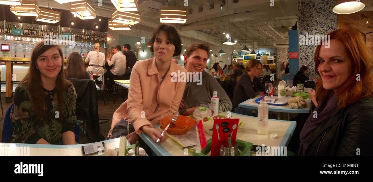 Junge russische Volk ein ein modernes Restaurant in Moskau genießen - Smartphone-aufgenommenes Stockfoto